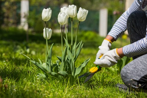 Worker wearing PPE including helmet and high-visibility jacket on a landscaping job